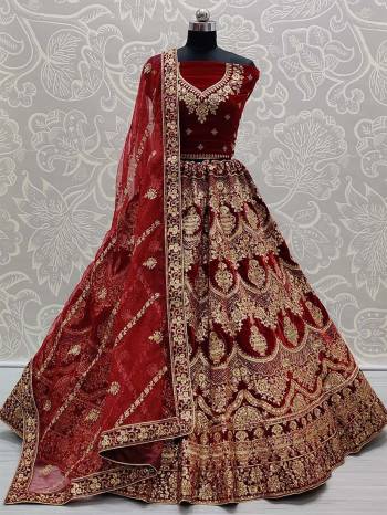 Heavy Designer Lehenga Choli In Maroon Color Fabricated On Velvet Beautified With Heavy Attractive Embroidery And Dupatta Are Soft Net In Maroon Color. 