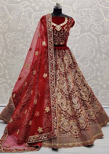 Heavy Designer Lehenga Choli In Maroon Color Fabricated On Velvet Beautified With Heavy Attractive Embroidery And Dupatta Are Soft Net In Maroon Color. 