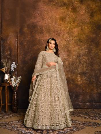 Flaunt Your Rich And Elegant Taste Wearing This Heavy designer Floor Length Suit In All Over Beige Color. Its Top And Dupatta Are Net In Heavy Embroidry Based Paired With Santoon Bottom.