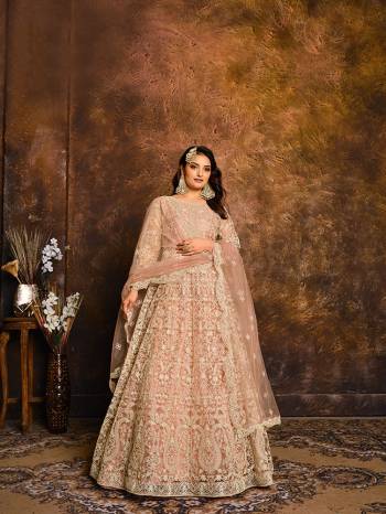 Flaunt Your Rich And Elegant Taste Wearing This Heavy designer Floor Length Suit In All Over Fawn Color. Its Top And Dupatta Are Net In Heavy Embroidry Based Paired With Santoon Bottom.