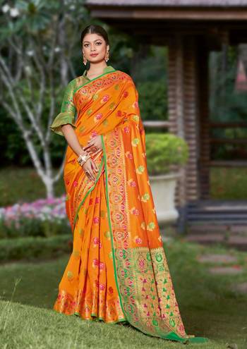 Look Attractive Wearing This Orange Colored Saree Paired With Green Colored Blouse.  This Heavy Designer Saree Is Banarasi Silk Based Which Gives A Rich Look To Your Personality. Buy This Pretty Saree Now.