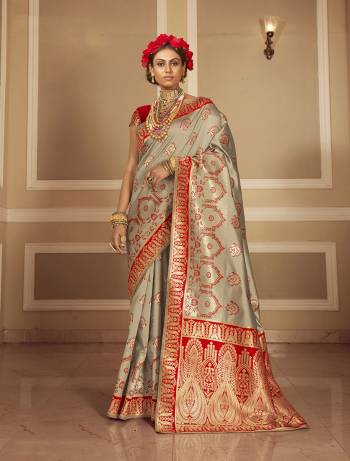 Look Attractive Wearing This Grey Colored Saree Paired With Red Colored Blouse.  This Heavy Designer Saree Is Banarasi Silk Wevon Jacquard Based Which Gives A Rich Look To Your Personality. Buy This Pretty Saree Now.