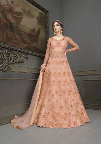 Flaunt Your Rich And Elegant Taste Wearing This Designer Semi-Stitched Floor Length Gown In Salmon Color Paired With Salmon Colored Dupatta. This Pretty Gown And Dupatta Are Fabricated On Net Beautified With Pretty Embroidery And Hand Work Giving An Attractive Look. 