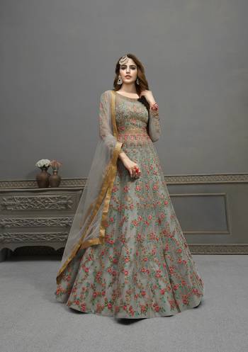 Flaunt Your Rich And Elegant Taste Wearing This Designer Semi-Stitched Floor Length Gown In Grey Color Paired With Grey Colored Dupatta. This Pretty Gown And Dupatta Are Fabricated On Net Beautified With Pretty Embroidery And Hand Work Giving An Attractive Look. 