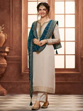 Grab This Very Beautiful Designer Straight Suit In Beige Color Paired With Pretty Embroidered Contrasted Colored Dupatta. Its Top Is Fabricated On Satin Georgette Paired With Santoon Bottom and Chinon Fabricated Dupatta. Buy This Designer Embroidered Suit Now