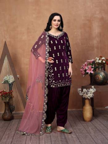 Get Ready For The Upcoming Festive And Wedding Season With This Designer Patiala Suit In Pine Wine Color Paired With Pink Colored Dupatta. Its Embroidered Top Is Fabricated On Velvet Paired With Santoon Bottom And Net Fabricated Gota Patti Border Dupatta. It Is Light Weight And Easy To Carry Throughtout The Gala. Buy this Suit Now.