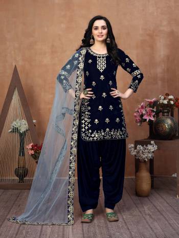 Get Ready For The Upcoming Festive And Wedding Season With This Designer Patiala Suit In Pine Nevy Blue Color Paired With Blue Colored Dupatta. Its Embroidered Top Is Fabricated On Velvet Paired With Santoon Bottom And Net Fabricated Gota Patti Border Dupatta. It Is Light Weight And Easy To Carry Throughtout The Gala. Buy this Suit Now.