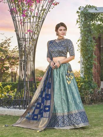 Garb This Partywear Designer Lehenga Choli And Dupatta In Fine Color Fabricated On Silk Beautified Fabric With Heavy Designer Weaving Butti Border Work. 