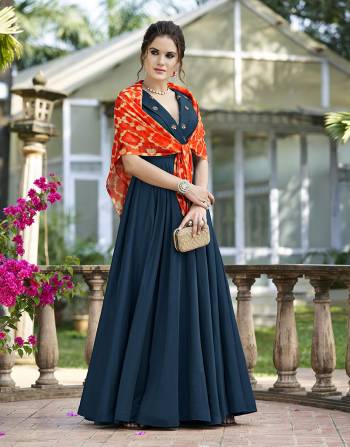 You Will Definitely eArn Lots Of Compliments Wearing This Designer Gown In Blue Color Paired With An Orange Colored Printed Stole. This Pretty gown Is Beautified With Hand Work Butti. 