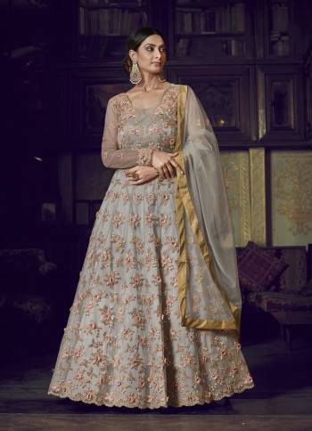 Flaunt Your Rich And Elegant Taste Wearing This Designer Semi-Stitched Floor Length Gown In Grey Color Paired With Grey Colored Dupatta. This Pretty Gown And Dupatta Are Fabricated On Net Beautified With Pretty Embroidery Giving An Attractive Look. 