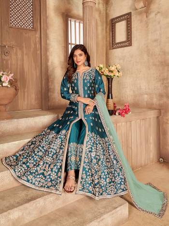 Get Ready For The Upcoming Festive And Wedding Season With This Designer Suit In Teal Blue Color. This Suit Is Art Sllk Based Beautified With Heavy Real Mirror Embroidery Work All Over It. Buy Now