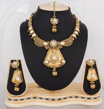 Heavy Looking Necklace Set Is Here In Golden Color Beautified With White Colored Stones. This Lovely Set Can Be Paired With any Colored Traditional Attire. Buy It Now.