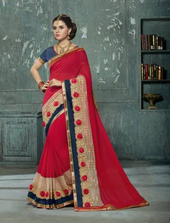 Adorn The Angelic Look Wearing This Saree In Red Color Paired With Contrasting Navy Blue Colored Blouse. This Saree Is Fabricated On Chiffon Paired With Art Silk Fabricated Blouse. It Has Attractive Embroidered Lace Border With 3D Flowers.