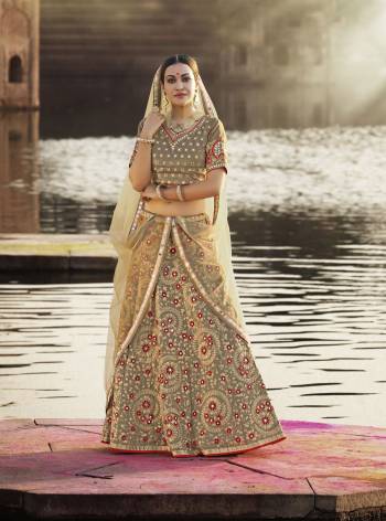 Here Is A New And Unique Shade With This Sand Grey Colored Lehenga Choli Paired With Cream Colored Dupatta. This Pretty Embroidered Lehenga Choli Is Fabricated On Art Silk Paired With Net Fabricated Dupatta. It Has Embroidery In Contrasting Red Colored Flowers and JAri Embroidery.