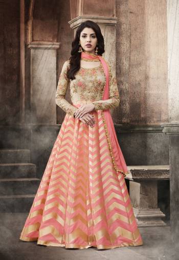 Here Is A Very Pretty Designer Floor Length Suit In Peach And Beige Color Paired With Peach Colored Bottom And Dupatta. Its Top Is Fabricated On Brocade And Art Silk Paired With Santoon Bottom And Chiffon Dupatta. It Has Beautiful Attractive Embroidery Over Its Yoke. Buy It Now.