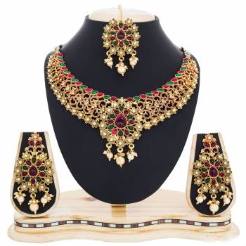 This Wedding Season Catch All The Lime Light Wearing This Heavy Necklace Set In Golden Color Beautified With Multi Colored Stones. This Necklace set Is Made Of Mix Metal Which Is Easy To carry Throughout The Gala. 