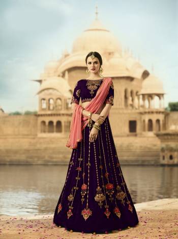 This Wedding Season, Earn Lots Of Compliments Wearing This Designer Lehenga Choli In Purple Color Paired With Contrasting Pink Colored Dupatta. This Lehenga And Choli Are Fabricated On Velvet Paired With Net Fabricated Dupatta. Its Beautiful And Attractive Embroidery Completes The Trick. Buy This Designer Lehenga Choli Now.