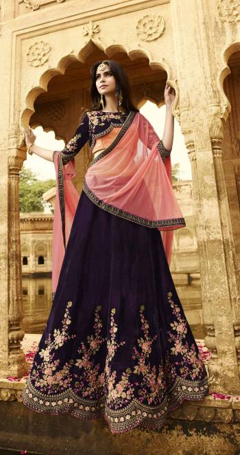 This Wedding Season, Earn Lots Of Compliments Wearing This Designer Lehenga Choli In Purple Color Paired With Contrasting Pink Colored Dupatta. This Lehenga And Choli Are Fabricated On Velvet Paired With Net Fabricated Dupatta. Its Beautiful And Attractive Embroidery Completes The Trick. Buy This Designer Lehenga Choli Now.