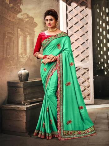 Add This Pretty Shade To Your Wardrobe With This Saree In Sea Green Color Paired With Contrasting Red Colored Blouse. This Saree Is Fabricated On Art Silk Paired With Art Silk Fabricated Blouse. It Has Embroidery Over The Lace Border And Embroidered Motifs.