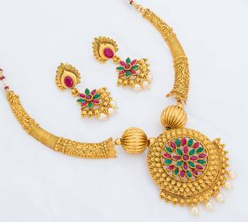 Make That Simple Dress A Heavy One Pairing It Up With This Beautiful Necklace Set In Golden Color Beautified With Pink And Green Colored Stone Work. It Is Light Weight And Ensures Superb Comfort Throughout The Gala.