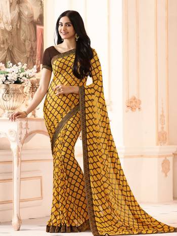 For Your Casual Wear, Grab This Saree In Yellow Color Paired With Contrasting Brown Colored Blouse, This Saree Is Fabricated On Georgette Paired With Art Silk Fabricated Blouse. It Has Simple Prints All Over The Saree And Lace Border. 