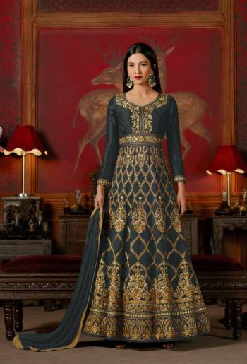 Flaunt Your Rich And Elegant Taste Wearing This Designer Floor Length Suit In Dark Grey Color Paired With Dark Grey Colored Bottom And Dupatta. Its Top Is Fabricated On Art Silk Paired With Santoon Bottom And Chiffon Dupatta. It Is Beautified With Heavy Embroidery All Over The Top.