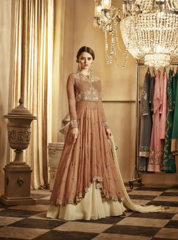 Here Is A Designer Indo-Western Suit In Brown Colored Top Paired With Cream Colored Lehenga And Dupatta. Its Top And Lehenga Are Fabricated On Georgette Paired With Chiffon Dupatta.Its Beautiful Up And Down Pattern With Attractive Embroidery And Elegant Color Combination Will Earn You Lots Of Compliments From Onlookers.