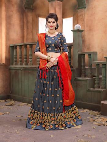 Flaunt Your Rich And Elegant Taste Wearing This Designer Lehenga Choli In Grey Color Paired With Contrasting Orange Colored Dupatta. Its Blouse And Lehenga Are Fabricated On Soft Silk Paired With Banarasi Art Silk Fabricated Dupatta. Its Fabric And Embroidery Gives A Rich Look To Your Personality.