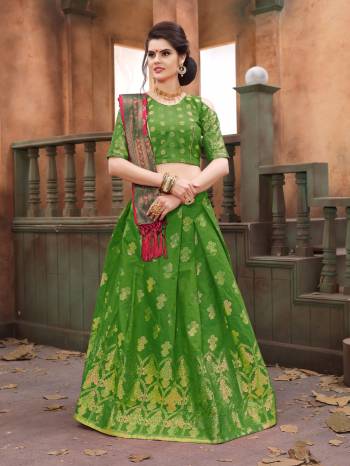 Grab This Desiger Silk Lehenga Choli In Green Color Paired With Contrasting Dark Pink Colored Dupatta. Its Lehenga, Choli And Dupatta Are Fabricated On Banarasi Art Silk Beautified With Weave Al Over It. It Attractive Color Combination Will Earn You Lots Of Compliments From Onlookers.