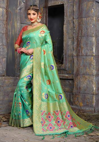 Very Pretty Shade In Green Is Here With This Saree In Light Green Color Paired With Contrasting Peach Colored Blouse. This Saree And Blouse Are Fabricated Of Art Silk Beautified With Weave All Over It. Buy This Saree Now.