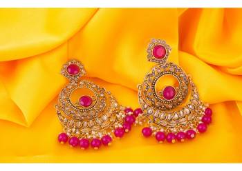 Here Is A Very Pretty Pair Of Earrings In Golden Color Beautified With Dark Pink Colored Stone Work. You Can Pair This Up With Pink Or Any Contrasting Colored Ethnic Attire. Buy Now.