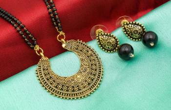 Here Is An Attractive Traditonal Patterned Mangalsutra Set In Golden Color. This Mangalsutra Comes With A Pair Of Earrings Beautified With Moti Work. This Unique Patterned Mangalsutra Will Earn You Lots Of Compliments From Onlookers. Buy Now.