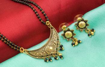 Here Is An Attractive Traditonal Patterned Mangalsutra Set In Golden Color. This Mangalsutra Comes With A Pair Of Earrings Beautified With Moti Work. This Unique Patterned Mangalsutra Will Earn You Lots Of Compliments From Onlookers. Buy Now.