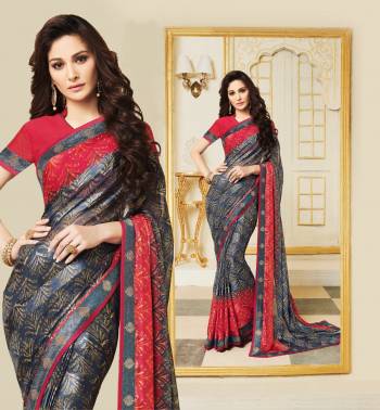 Be It Your Casual Or Semi-Casual Wear, Grab This Saree In Dark Grey Color Paired With Contrasting Red Colored Blouse. This Saree Is Fabricated On Silk Georgette Paired With Art Silk Fabricated Blouse. It Is Beautified With Prints All Over. 