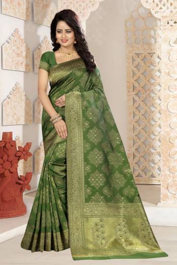 A Must Have Shade In Every Womens Wardrobe Is Here With This Silk Saree In Olive Green Color Paired With Olive Green Colored Blouse. This Saree And Blouse Are Fabricated On Kanjivaram Art Silk Beautified With Weave. Buy This Saree Now.