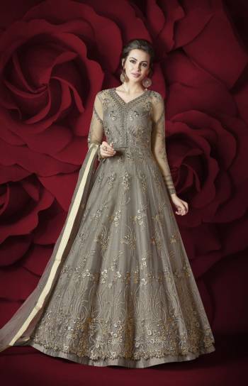 Flaunt Your Rich and Elegant Taste Wearing This Designer Floor Length Suit In Grey Colored Top Paired With Grey Colored Bottom And Dupatta. Its Top Is Fabricated On Net Paired With Silk Bottom And Net Dupatta. Its Rich and Elegant Embroidery Will Earn Your Lots Of Compliments From Onlookers.