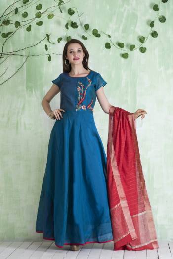 For An Attractive Look with Bright Colors, Grab This Deisgner Floor Length Suit In Blue Color Paired With Blue Colored Bottom And Contrasting Red Colored Dupatta. Its Top Is Fabricated On Chanderi Paired With Lycra Leggings And Viscose Jacquard Dupatta. 