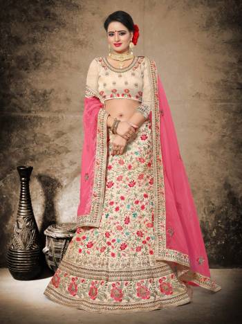 Flaunt Your Rich And Elegant Taste Wearing This Heavy Designer Lehenga Choli In Beige Color Paired With Contrasting Pink Colored Blouse. This Lehenga And Choli Are Fabricated On Art Silk Paired With Net Fabricated Dupatta. It Has Contratsing Colored Thread Embroidery Making It More Appealing.