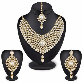 Here Is A Heavy Necklace Set To Pair Up With Your Heavy Ethnic Dress Such As Heavy Lehenga Or Floor Length Suit. This Set Is Also Suitable For Bridal Wear. It Is In Golden Color Beautified With White Colored Stones, Buy Now.