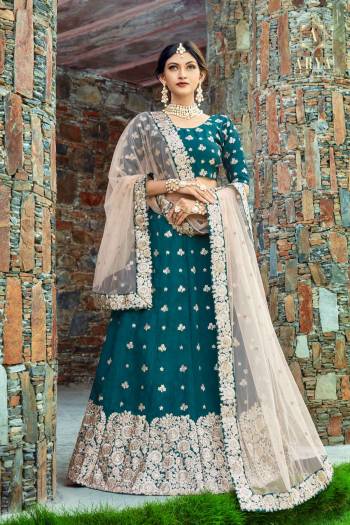 Featuring Teal Blue lehenga set in art silk base. Lehenga is intricated with zari floral motifs further with dori, sequins. It comes with a round neck blouse with zari, sequins and dori embroidery dupatta.