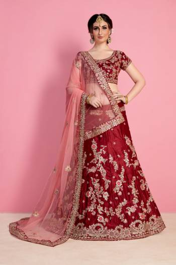 For A Royal Queen Like Look, Grab This Heavy Designer Lehenga Choli In Maroon Color Paired With Light Peach Colored Dupatta. Its Blouse And Lehenga Are Fabricated On Velvet Silk Paired With Net Fabricated Dupatta. Its All Over Heavy Embroidery And Pretty C