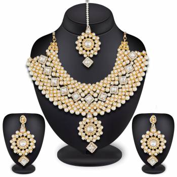 To Give A Heavy And Enhanced Look, Grab This Beautiful Necklace Set Beautified With Stones And Pearls. It Comes With A Pair Of Earrings And Maang Tika. This Can Be Paired With Any Colored Traditional Attire. Buy Now.