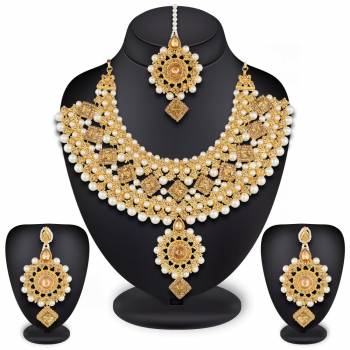 To Give A Heavy And Enhanced Look, Grab This Beautiful Necklace Set Beautified With Stones And Pearls. It Comes With A Pair Of Earrings And Maang Tika. This Can Be Paired With Any Colored Traditional Attire. Buy Now.