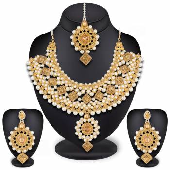 To Give A Heavy And Enhanced Look, Grab This Beautiful Necklace Set Beautified With Stones And Pearls. It Comes With A Pair Of Earrings And Maang Tika. This Can Be Paired With Any Colored Traditional Attire. Buy Now.