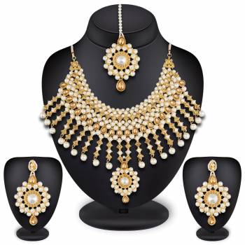 To Give A Heavy And Enhanced Look, Grab This Beautiful Necklace Set Beautified With Stones And Pearls. It Comes With A Pair Of Earrings And Maang Tika. This Can Be Paired With Any Colored Traditional Attire. Buy Now.