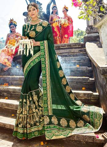 Celebrate this festive season wearing this designer saree in dark green color paired with dark green colored blouse. This saree is fabricated on chiffon silk paired with art silk fabricated blouse. Inspite of heavy embroidery this saree enusres superb comfort throughout the gala. buy now.