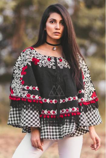 black floral embroiderd poncho on black khadi fabric embilished with red pom pom and black tassel lace. Attached with black and white chex frill all over the poncho