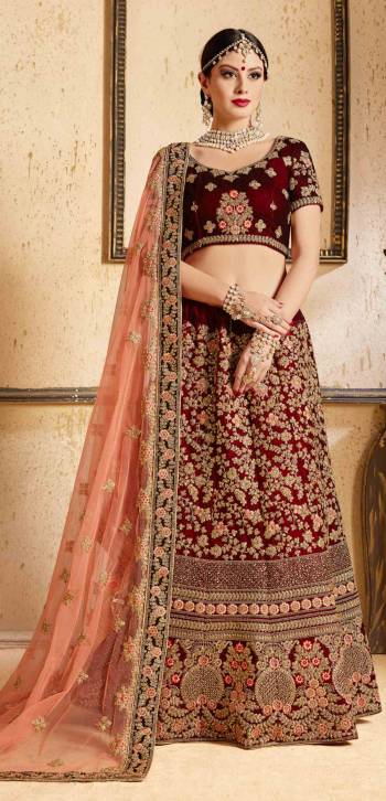 Get Ready For Your D-day With This Heavy Designer Bridal Lehenga choli In Maroon Color Paired With Contrasting Peach Colored Dupatta. This Velvet Based Lehenga And Choli Are Beautified With Heavy Jari And Resham Embroidery With Stone Work. Its Soft Net Dupatta Can Be Drape As Per It Is Suitable To You. Its Fabric Also Ensures Superb Comfort Throughout The Gala And Earn You Lots Of Compliments From Onlookers. Buy Now.