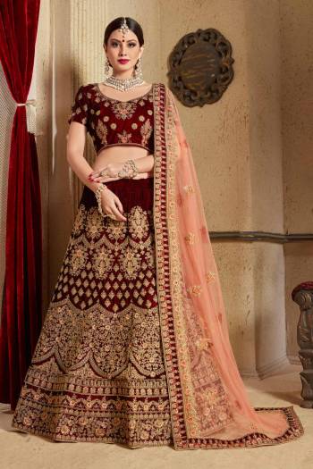 Get Ready For Your D-day With This Heavy Designer Bridal Lehenga choli In Maroon Color Paired With Contrasting Peach Colored Dupatta. This Velvet Based Lehenga And Choli Are Beautified With Heavy Jari And Resham Embroidery With Stone Work. Its Soft Net Dupatta Can Be Drape As Per It Is Suitable To You. Its Fabric Also Ensures Superb Comfort Throughout The Gala And Earn You Lots Of Compliments From Onlookers. Buy Now.