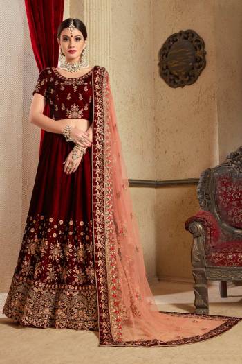 Get Ready For Your D-day With This Heavy Designer Bridal Lehenga choli In Maroon Color Paired With Contrasting Peach Colored Dupatta. This Velvet Based Lehenga And Choli Are Beautified With Heavy Jari And Resham Embroidery With Stone Work. Its Soft Net Dupatta Can Be Drape As Per It Is Suitable To You. Its Fabric Also Ensures Superb Comfort Throughout The Gala And Earn You Lots Of Compliments From Onlookers. Buy Now.